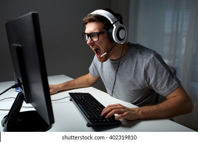 Technology, Gaming, Entertainment, Let's Play And People Concept - Angry Screaming Young Man In Headset With Pc Computer Playing Game At Home And Streaming Playthrough Or Walkthrough Video