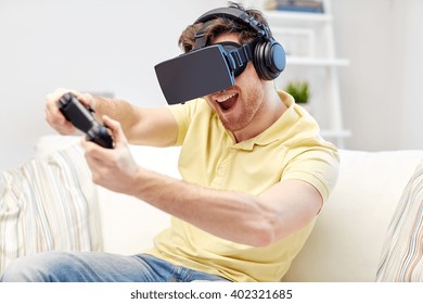 Technology, Gaming, Entertainment And People Concept - Happy Young Man With Virtual Reality Headset Or 3d Glasses With Controller Gamepad Playing Racing Video Game At Home