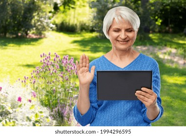 technology, gardening and old people concept - smiling senior woman using tablet computer having video call and waving hand over summer garden background - Powered by Shutterstock