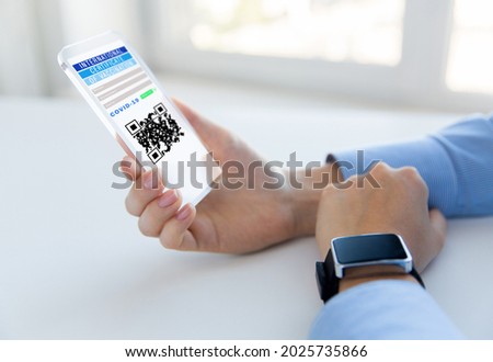 technology and health care concept - close up of woman's hands holding transparent smartphone with virtual immunity passport or international certificate of vaccination on screen