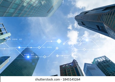 Technology hologram on low, wide angle view of glass and steel contemporary skyscrapers in financial downtown . The concept of developing coding and high-tech science. Double exposure.