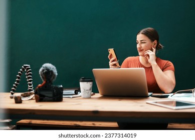 Technology lets me work from all devices. Cropped shot of an attractive young businesswoman sitting alone at her desk and using her cellphone.