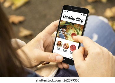technology and lifestyle concept: young woman with cooking blog on the screen phone at the park