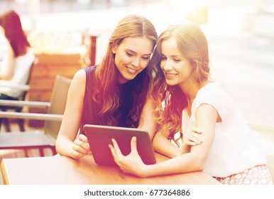 Technologie, Lebensstil, Freundschaft und Menschen Konzept - glückliche junge Frauen oder Teenagermädchen mit Tablet-PC im Café im Freien