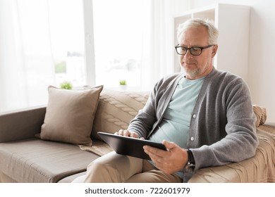Technology, Old Age, People And Lifestyle Concept - Senior Man With Tablet Pc Computer Sitting On Sofa At Home