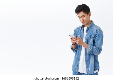 Technology, Online Lifestyle Concept. Portrait Of Handsome Young Taiwanese Man Sending Message, Using Internet To Pay Connect To App, Holding Smartphone Look At Display Pleased Smile