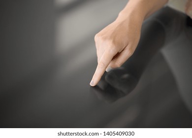 technology and people concept - hand using black interactive panel