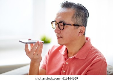 technology, people, lifestyle and communication concept - happy man using voice command recorder on smartphone at home - Powered by Shutterstock