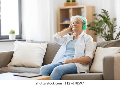 technology, people and lifestyle concept - happy senior woman in headphones and tablet pc computer listening to music at home - Powered by Shutterstock