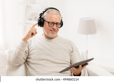 Technology, People, Lifestyle And Distance Learning Concept - Happy Senior Man With Tablet Pc Computer And Headphones Listening To Music At Home