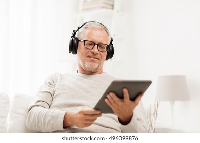 Technology, People, Lifestyle And Distance Learning Concept - Happy Senior Man With Tablet Pc Computer And Headphones Listening To Music At Home