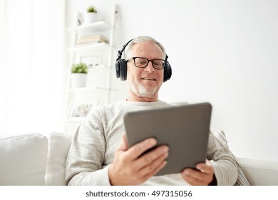 Technology, People, Lifestyle And Distance Learning Concept - Happy Senior Man With Tablet Pc Computer And Headphones Listening To Music At Home