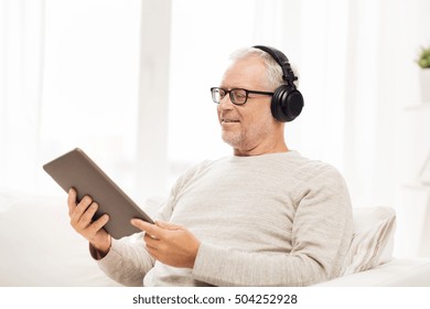 Technology, People, Lifestyle And Distance Learning Concept - Happy Senior Man With Tablet Pc Computer And Headphones Listening To Music At Home