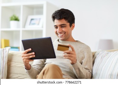 Technology, People And Online Shopping Concept - Smiling Man With Tablet Pc And Credit Card At Home