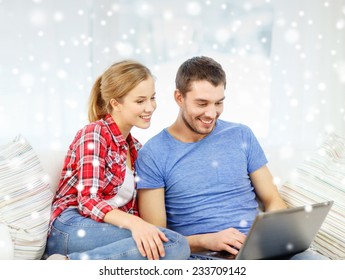Technologie, Menschen und Beziehungen Konzept - lächelndes Paar mit Laptop-Computer auf Sofa zu Hause sitzen