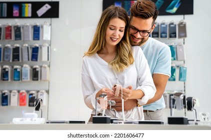 Technology People Smart Devices Concept. Happy Couple Buying New Smart Watch In Tech Store.