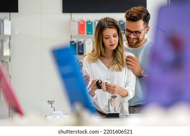 Technology People Smart Devices Concept. Happy Couple Buying New Smart Watch In Tech Store.