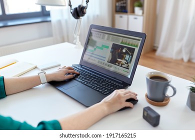 technology, post production and vlog concept - close up of woman working in video editor program on laptop computer working at home office