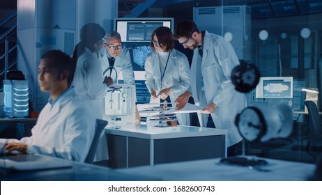 In Technology Research Laboratory: Diverse Team of Industrial Scientists, Engineers, Developers Work with Digital Whiteboard Showing Engine Blueprints, Efficiency Calculated by Neural Network - Powered by Shutterstock