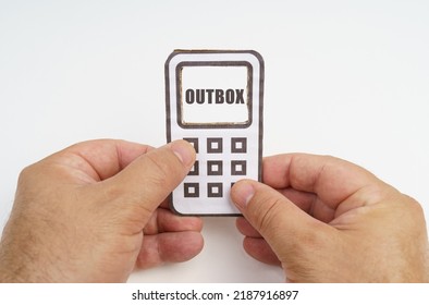 Technology and security concept. On a white background, in the hands of a person, a cardboard model of a telephone with an inscription on the screen - OUTBOX