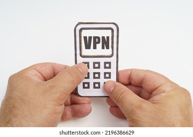 Technology and security concept. On a white background, in the hands of a person, a cardboard model of a telephone with an inscription on the screen - VPN