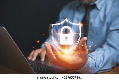 The technology of security for protect private data of personal. Technology, business, and innovation concept. Businessman holding a lock with a shield on hand to safeguard violation of privacy.