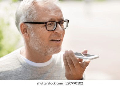 technology, senior people, lifestyle and communication concept - close up of happy old man using voice command recorder or calling on smartphone outdoors - Powered by Shutterstock