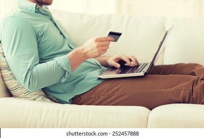 Technology, Shopping, Banking, Home And Lifestyle Concept - Close Up Of Man With Laptop Computer And Credit Card At Home