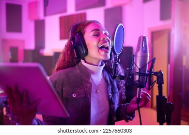 Technology, singing or woman on neon microphone, music studio lyrics or songwriting app in night recording. Singer, musician or artist on tablet in production, voice media or sound light performance - Powered by Shutterstock