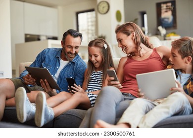 Technology, streaming and a happy family on the sofa for internet, social media and communication. Smile, bonding and a mother, father and children with a tablet and phone for online games at home - Powered by Shutterstock