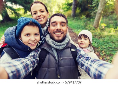 technology, travel, tourism, hike and people concept - happy family with backpacks taking selfie and hiking - Powered by Shutterstock