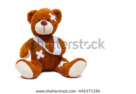 Teddy bear with bandages and broken hand isolated on white background