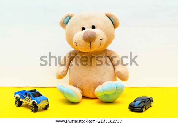 teddy bear with cars toys for children play on\
white yellow background, baby\'s childhood development, Educational\
toys for toddler kid\'s\
concept.