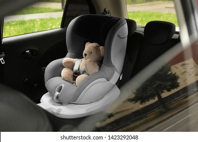 Teddy Bear In Child Safety Seat Inside Car. Danger Prevention