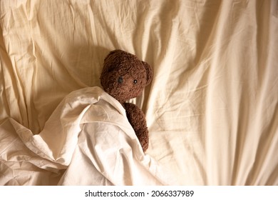 Teddy bear cuddly toy on bed sheet