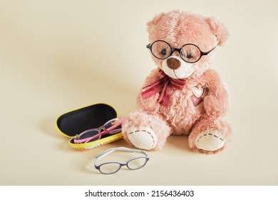 Teddy Bear With Eye Glasses On Beige Background Children's Glasses, Glasses For Children, Training Concept, Optics Shop