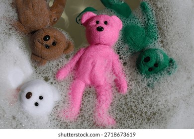 Teddy bear floating in soapy bubble water.