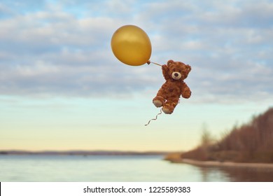 flying teddy bear with balloons