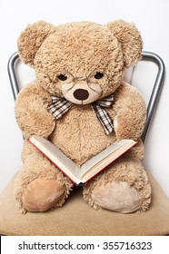 Teddy bear with glasses reading a book