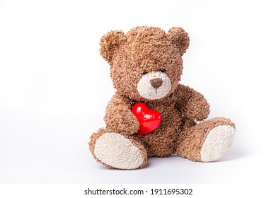 teddy bear holding heart isolated on white background, Valentines day . a soft bear toy holds a heart on a white background