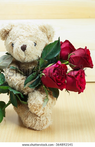 teddy bear holding roses