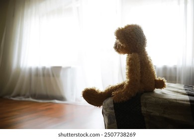 Teddy Bear Sitting by Sunlit Window Evoking Nostalgia and Solitude - Powered by Shutterstock