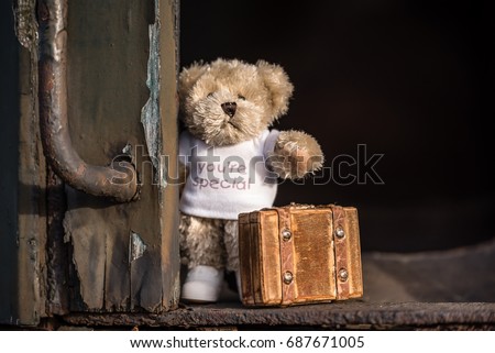 Teddy bear with suitcase says goodbye and goes on vacation by train.