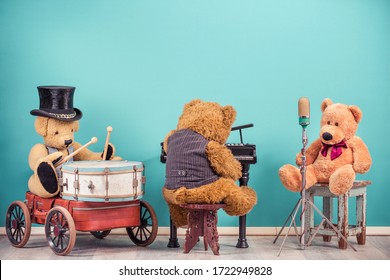Teddy Bear toys music band trio: vocalist with retro old microphone, bear in cylinder hat playing drum and grand piano player front mint blue wall background. Vintage nostalgia style filtered photo