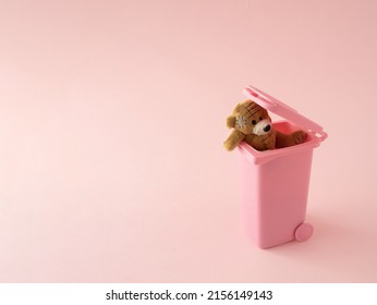 Teddy bear in trash.Thrown happiness and memories in garbage. Self love minimal concept on pink background