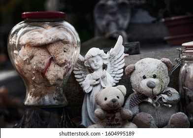 Teddy Bears, Angel And Other Toys On Baby Grave In The Cemetery. Сlose-up. (concept: Death, Loss).