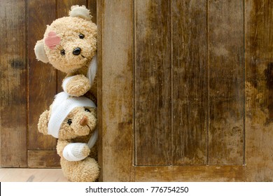 Teddy bears with bandages and broken hand on wood background,copy space.