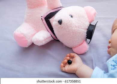 Teddy Bear's Eye Was Detached By Toddler And In Sleeping 10 Months Old Baby Hand, Poorly Attached Button Was Removed By Kid, Beware Of Choking Hazard For Children Concept, Warning For Parent