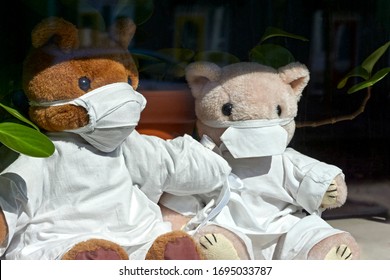 Teddy Bears With Face Masks And Medical Clothes Behind A Window Of A House In The Netherlands. The So Called Bear Hunts Keep Children Entertained During The Corona Virus Lockdown.