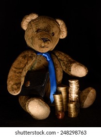 Teddy As A Rogue Businessman Who Makes Money Transactions Hidden In The Darkness. He Has A Black Briefcase Under His Arm And Stacked Coins In Front Of Him. 